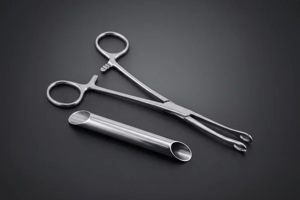 Silver piercing clamp and angled receiving tube on charcoal