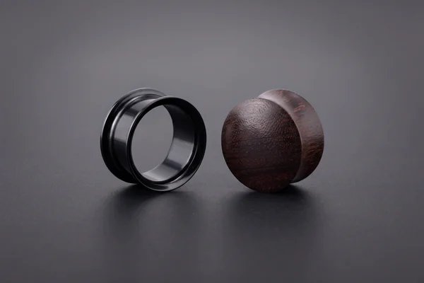 Black hollow tunnel beside a solid wooden plug